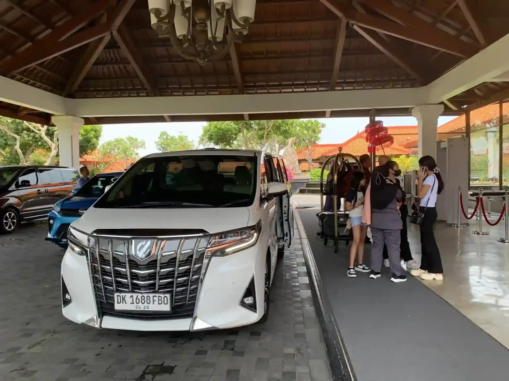 Toyota Alphard putih menunggu tamu di lobi drop-off hotel Bali